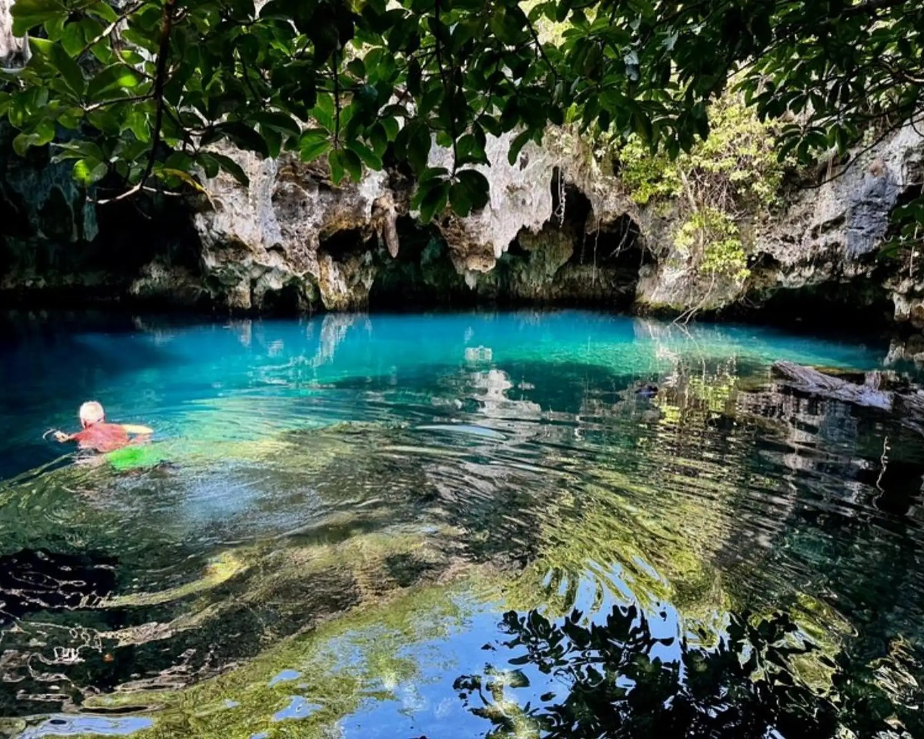 Tour group exploring the ancient limestone chambers of Maalum Cave in Zanzibar